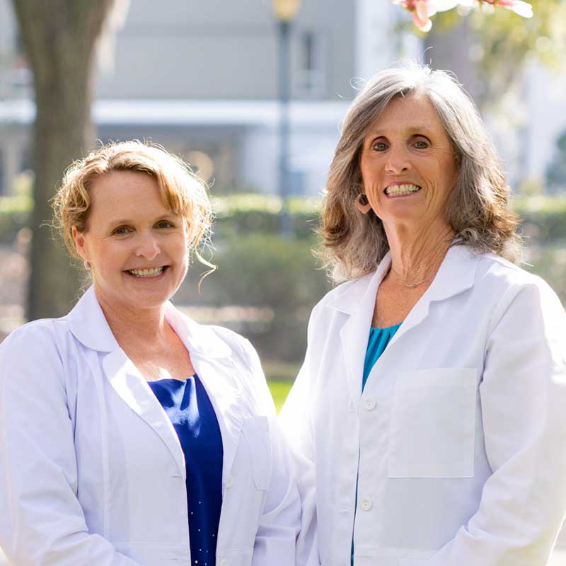 Dr. Trisha and Dr. Karla having a friendly conversation outdoors.